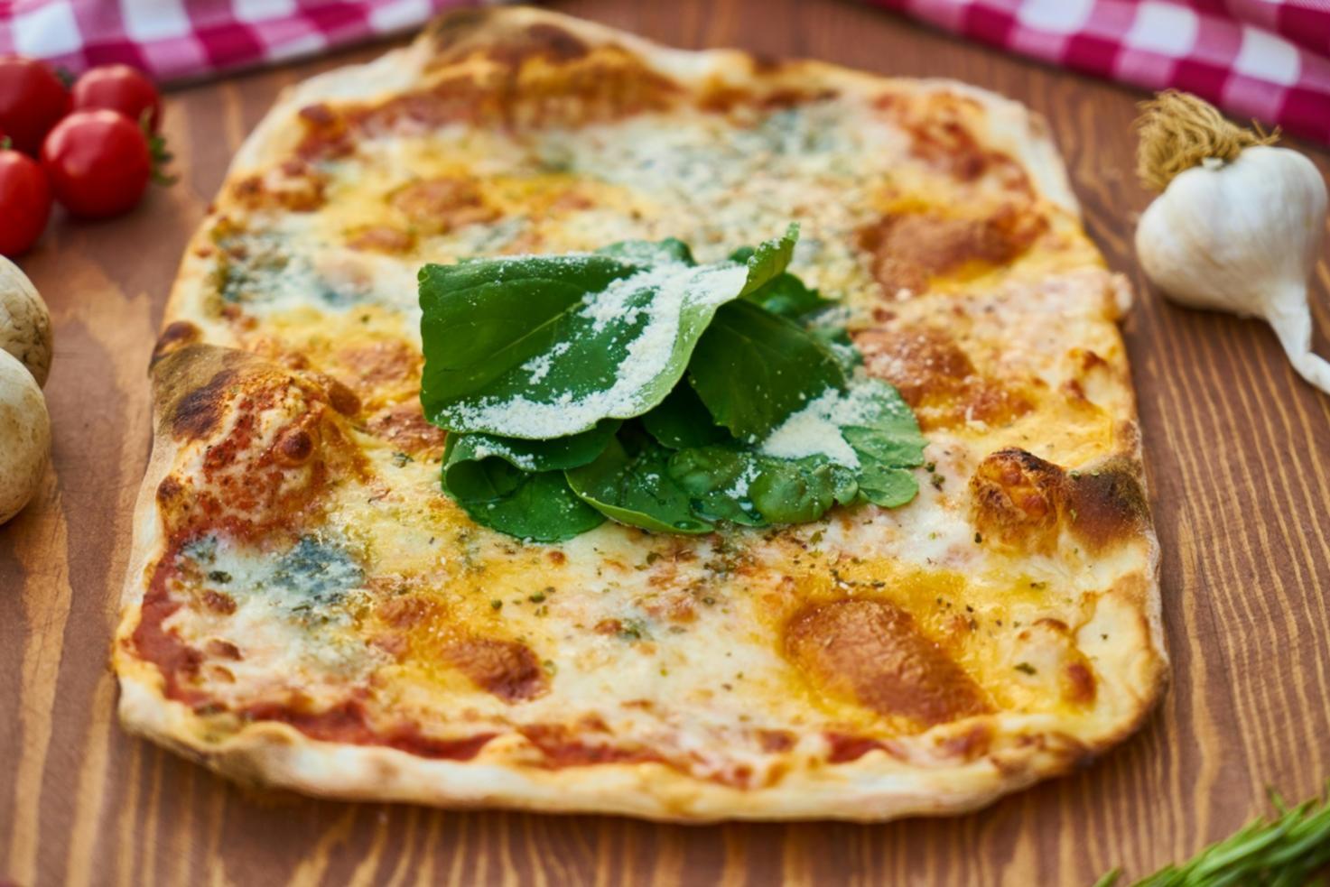 Close-up view of artisan pizza-making process showing dough stretching and ingredient preparation